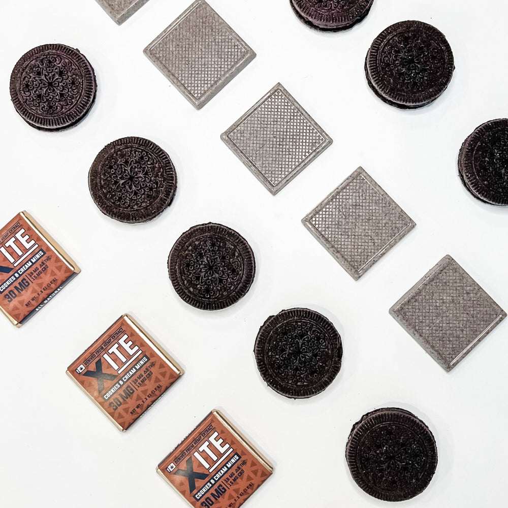 3 cookies and cream minis 30mg by xite next to rows of chocolate and cream cookies