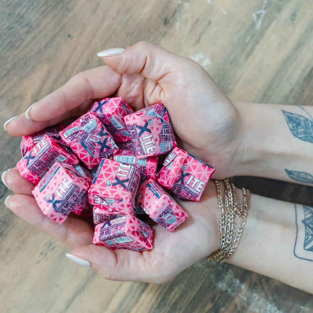 hands holding 30mg strawberry chews by xite