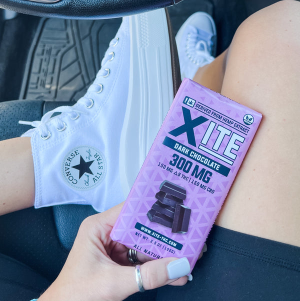 a 300mg dark chocolate bar by xite next to some converse shoes 